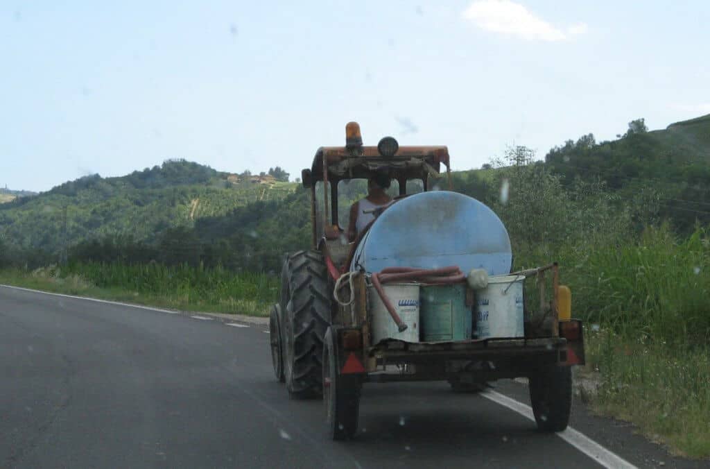 A farm tractor drives along the road in Italy.