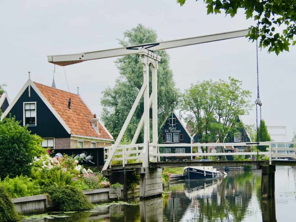 An old wooden drawbridge stands over the water in a Dutch town.