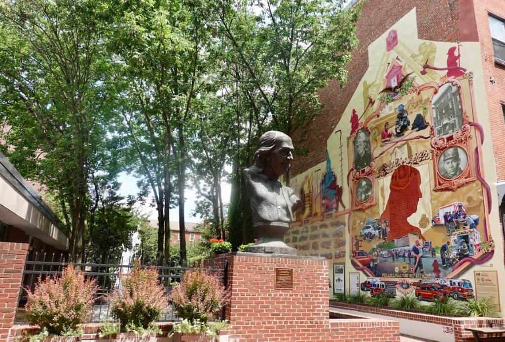 A statue and mural commemorating Ben Franklin in Philadelphia.