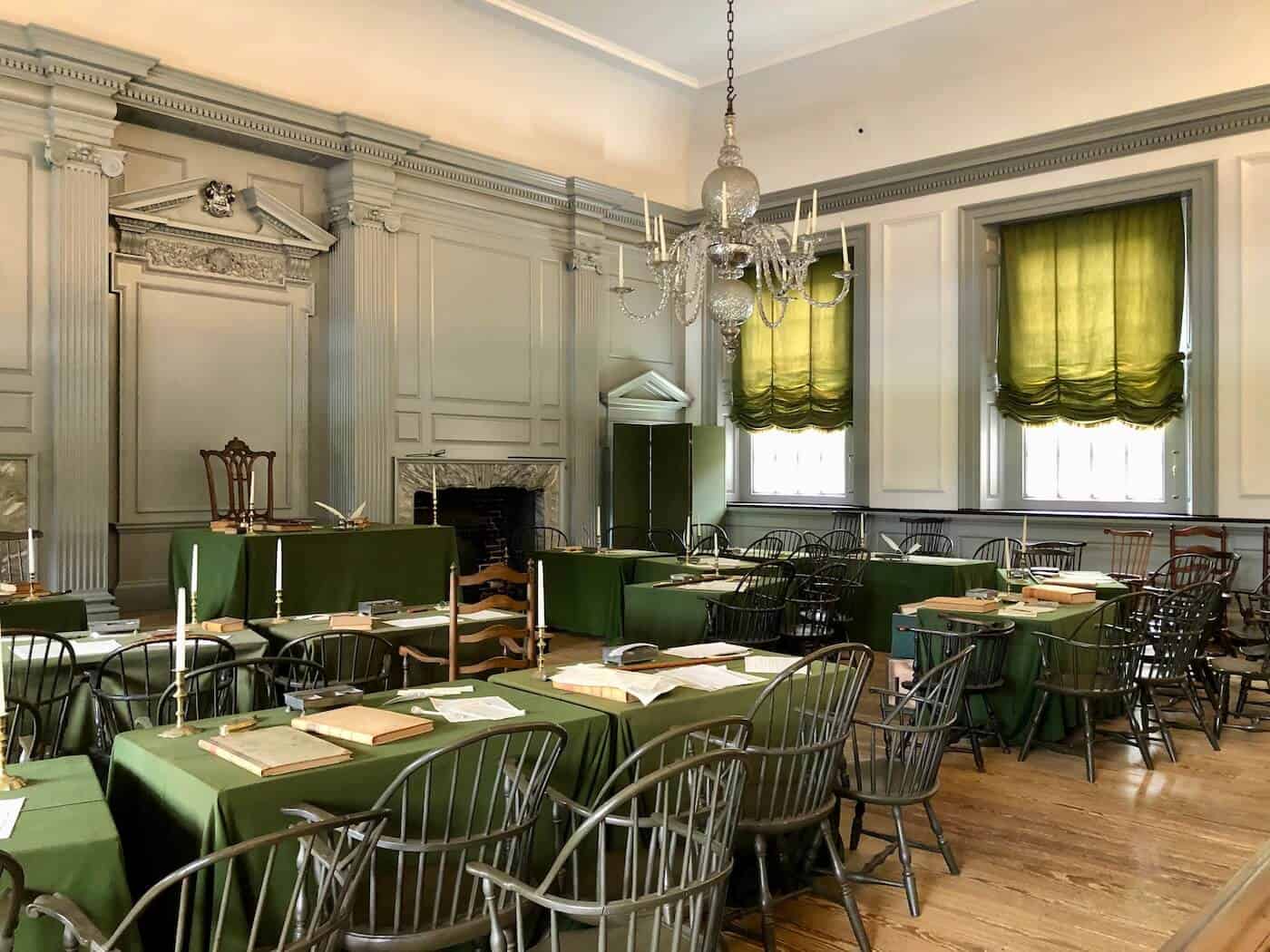 A picture of the inside of Independence Hall in Philadelphia showing the tables and chairs used by the founding fathers.