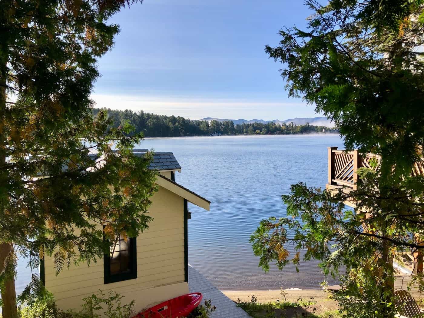 A view of a boathouse in the foreground and Mirror Lake in the background in Lake Placid village.