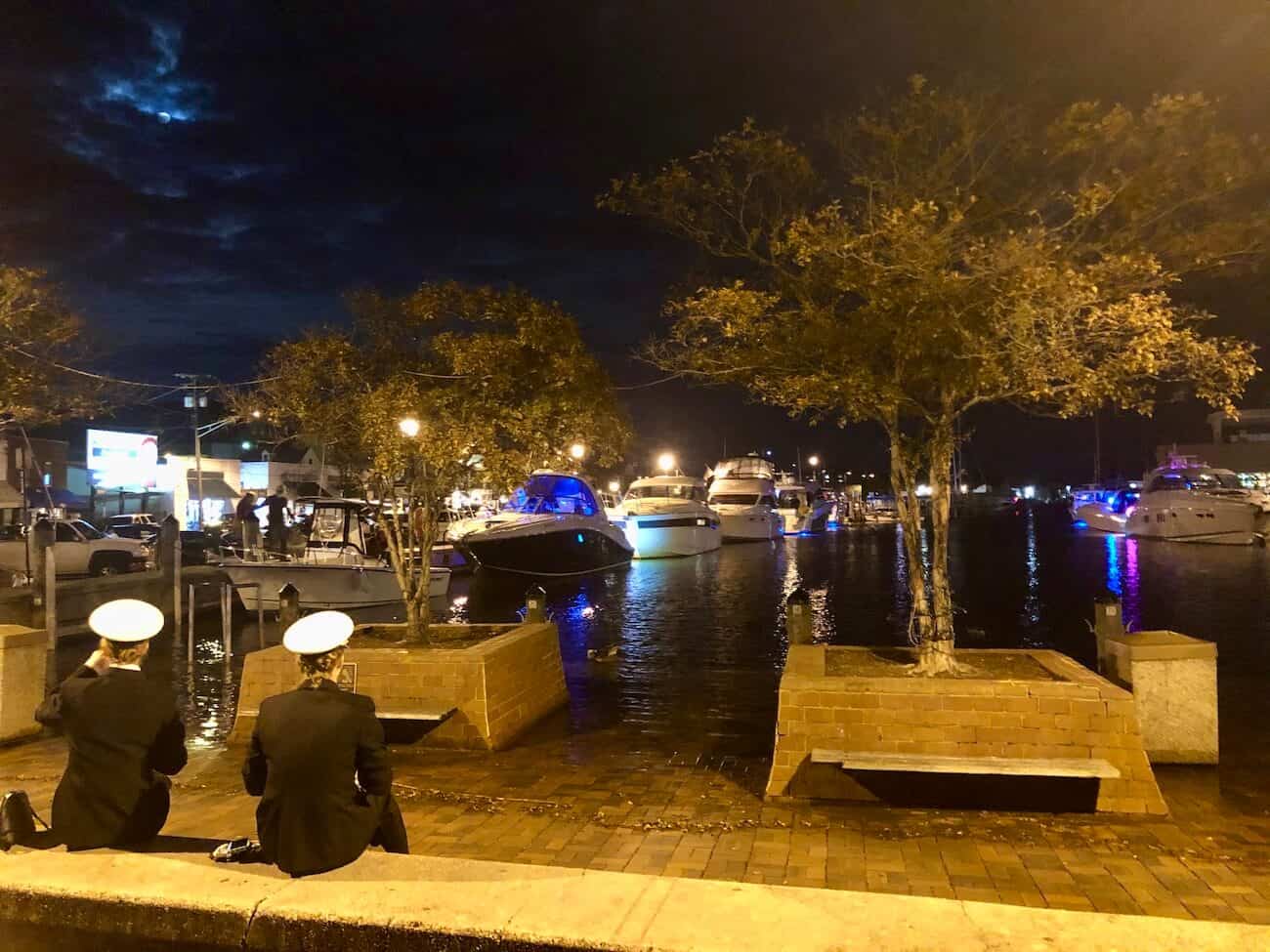 Midshipmen sit at the City Dock at dusk.