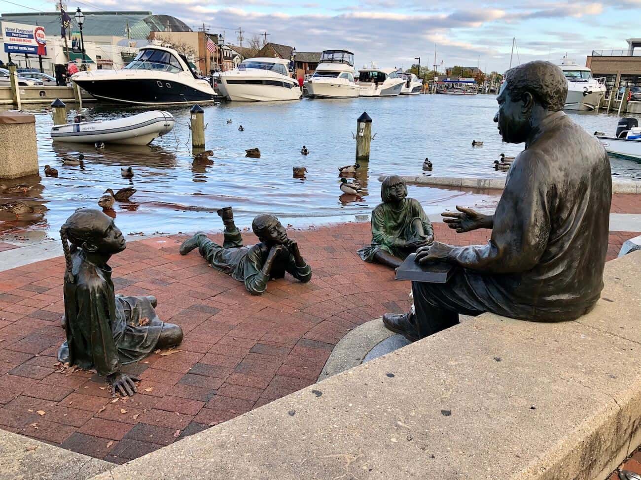 The Alex Haley Memorial at the City Dock with ducks, water, and boats in the background.