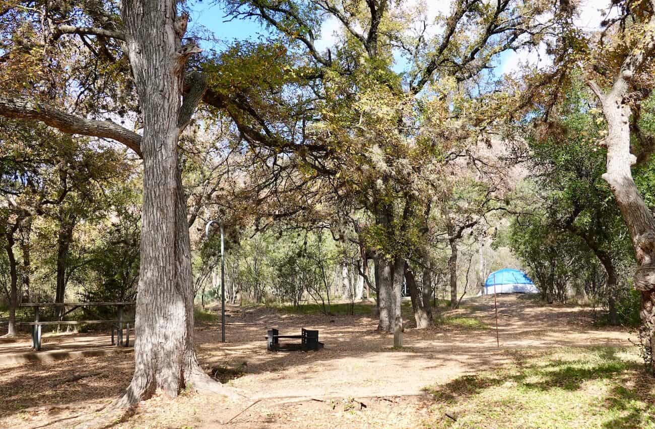A camping area with benches and fire pit at Enchanted Rock.
