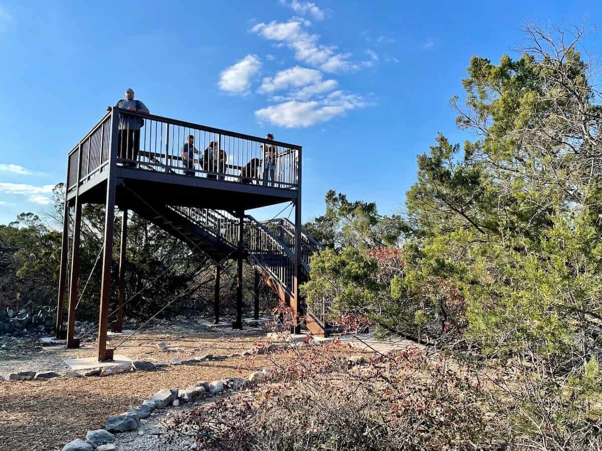 A wooden observation tower sits along a park trail.