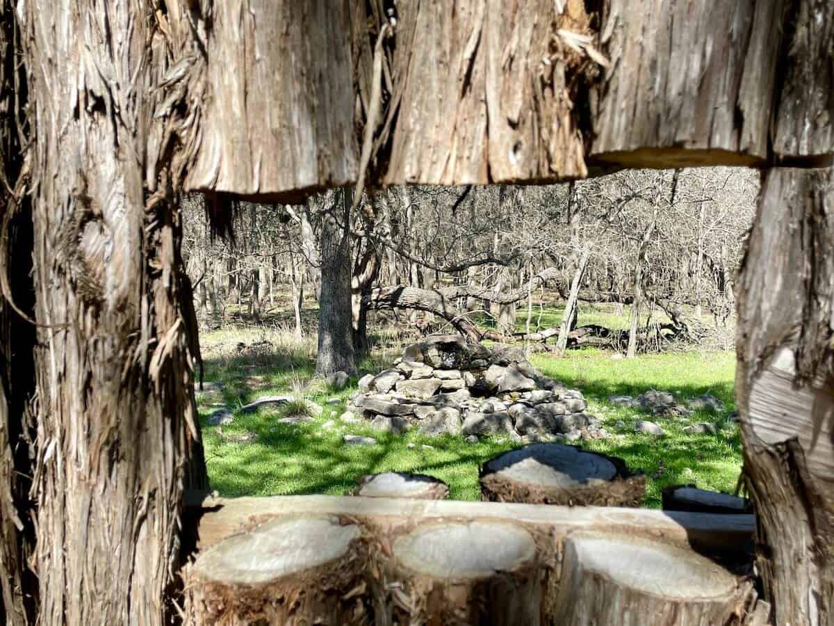A cut-out in a bird blind shows a rocky structure for birds to drink water.