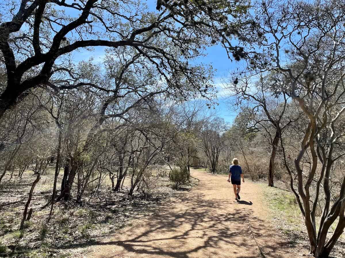 A person walks along Earth Trail at Hardberger Park.