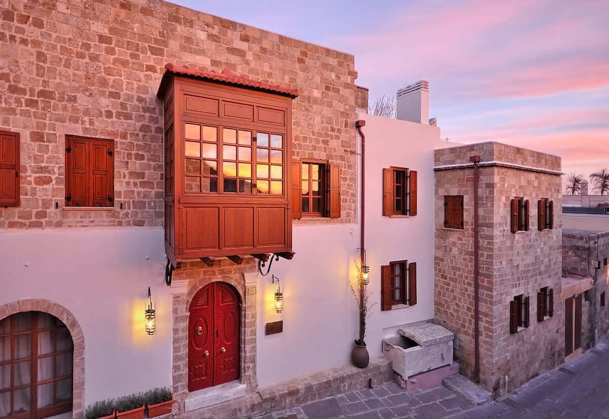 A stone facade and red doors are on the outside of a building.