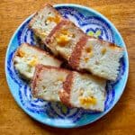 Six pieces of orange bread sit on a multicolored plate.