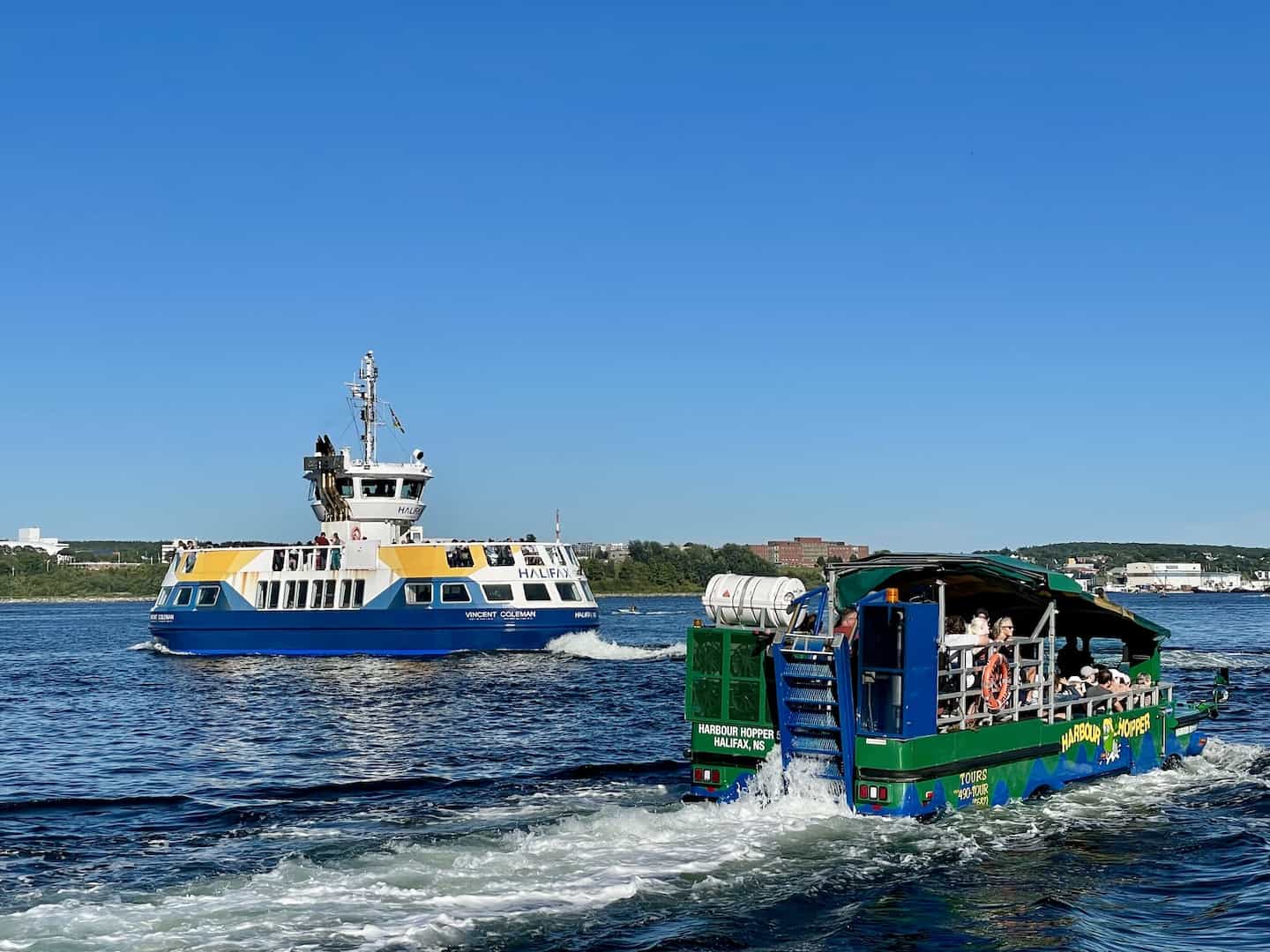 A ferry boat and a tour boat pass each other in the Halifax harbor.