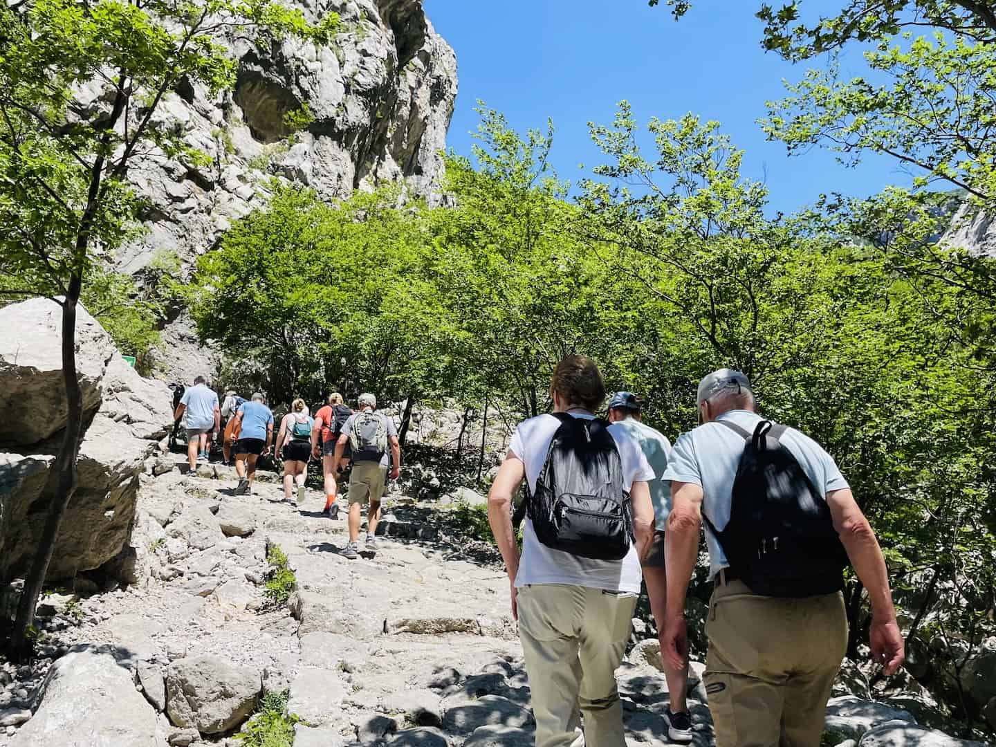On a Viking ocean cruise excursion, people hike up a rocky path at Paklenica National Park in Croatia.