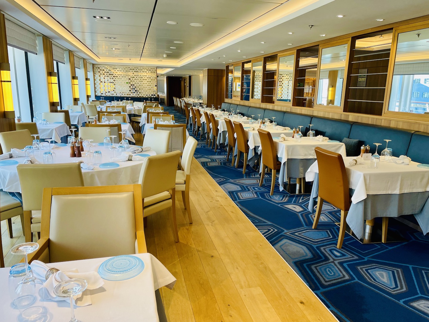 White tablecloths dress the tables surrounded by chairs at The Restaurant on a Viking Ocean cruise.