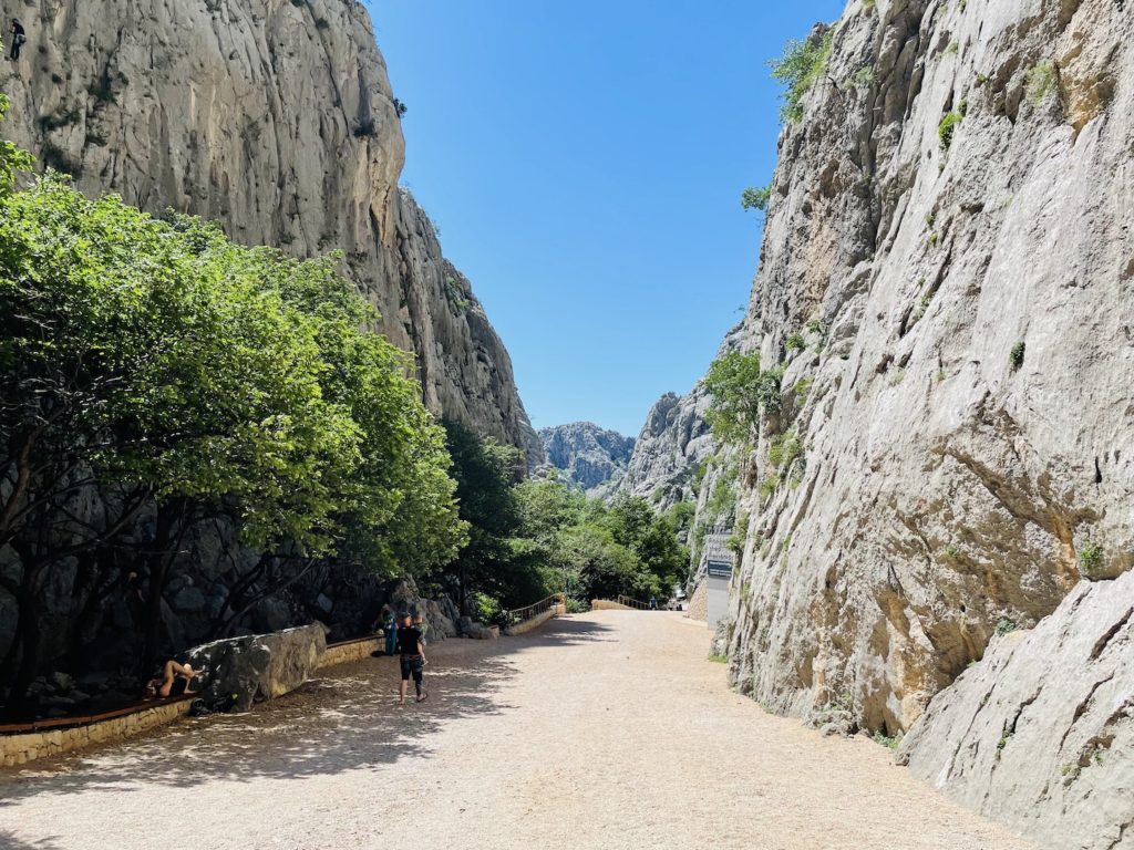 A gravel path guides hikers through a canyon between two mountain peaks near Zadar, Croatia.