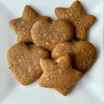 Six hazelnut molasses cookies (cut into hearts and stars) sit on a white plate.