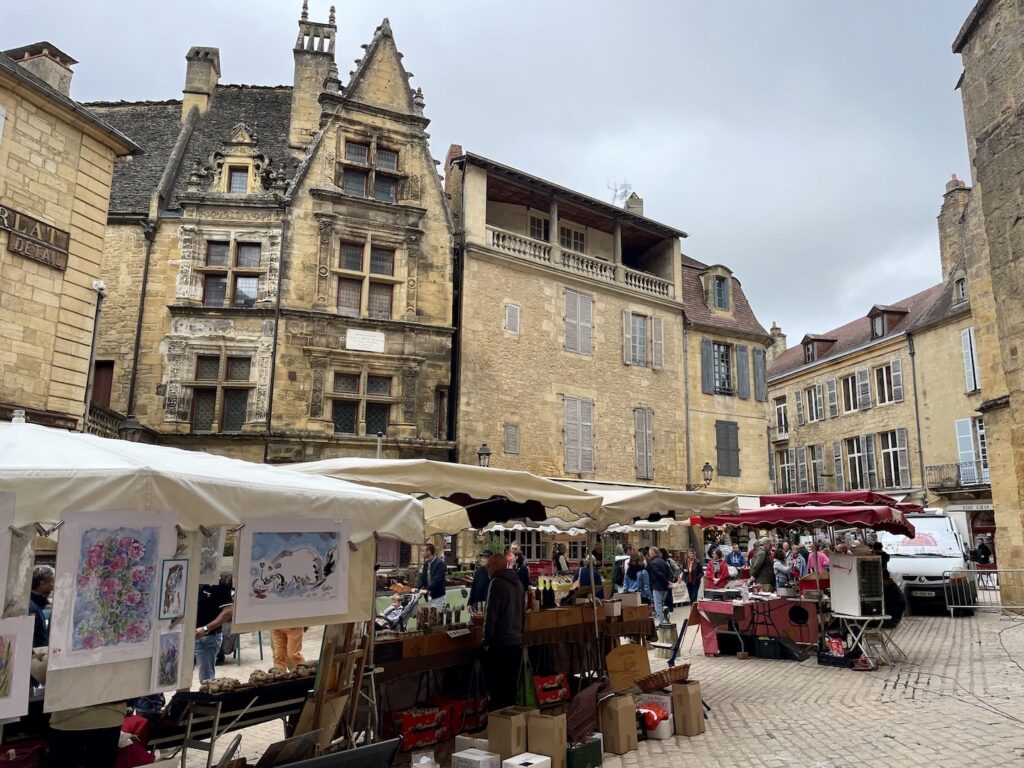 Centuries-old buildings stand in the background of a Saturday morning market in Sarlat, in southwest France.