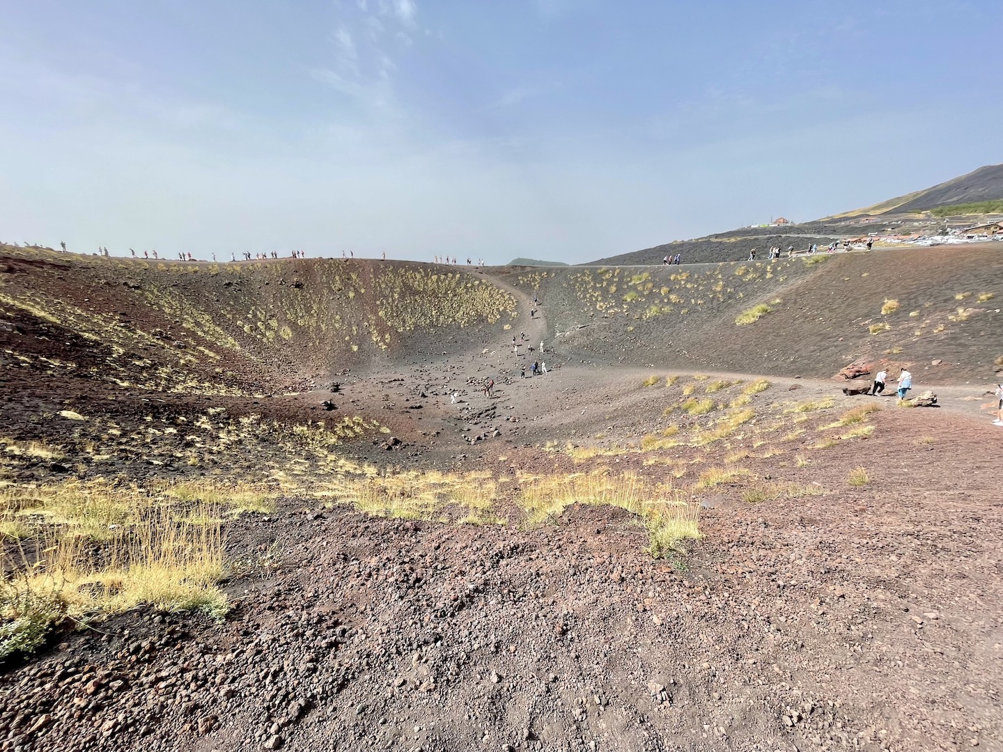 People walk along and in a crater at Mt. Etna in Sicily.