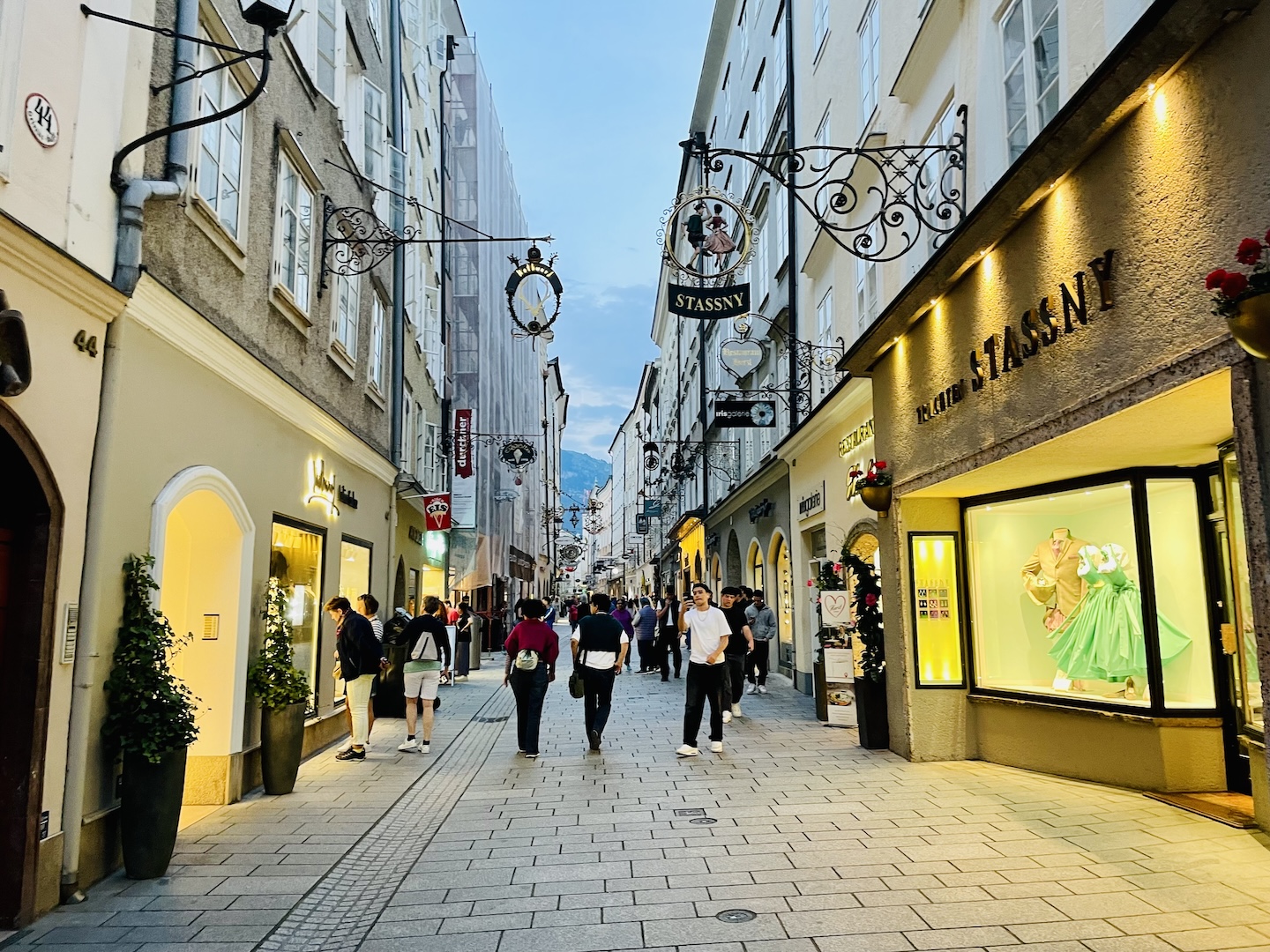 People walk along a pedestrian shopping street in Salzburg, Austria.